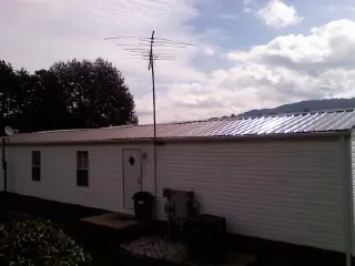 New metal roof on a single wide mobile home with a TV antenna in Coldwater