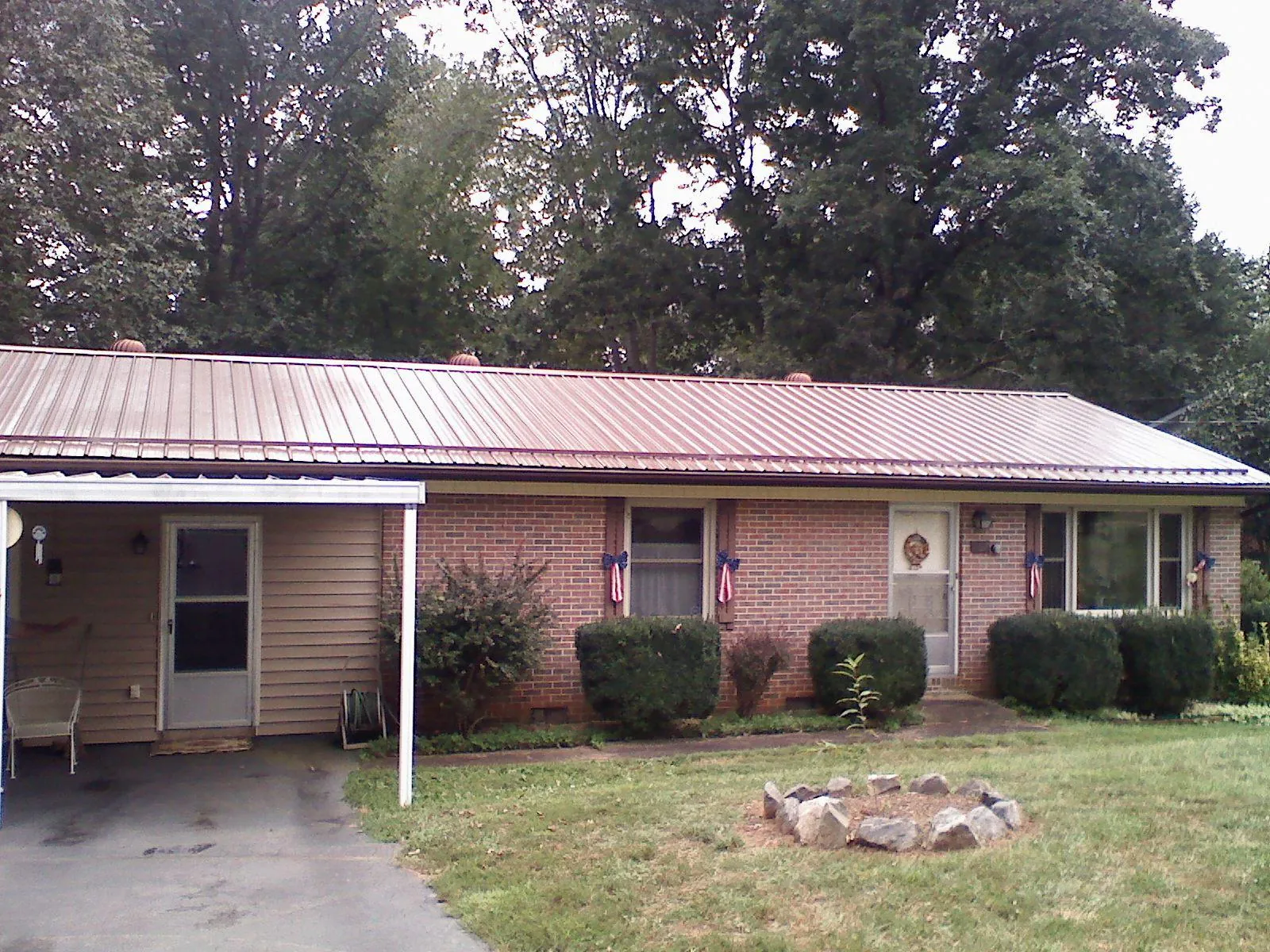 Bronze metal roof and carport on a brick ranch home — Roof Repair work by our crew in Coldwater